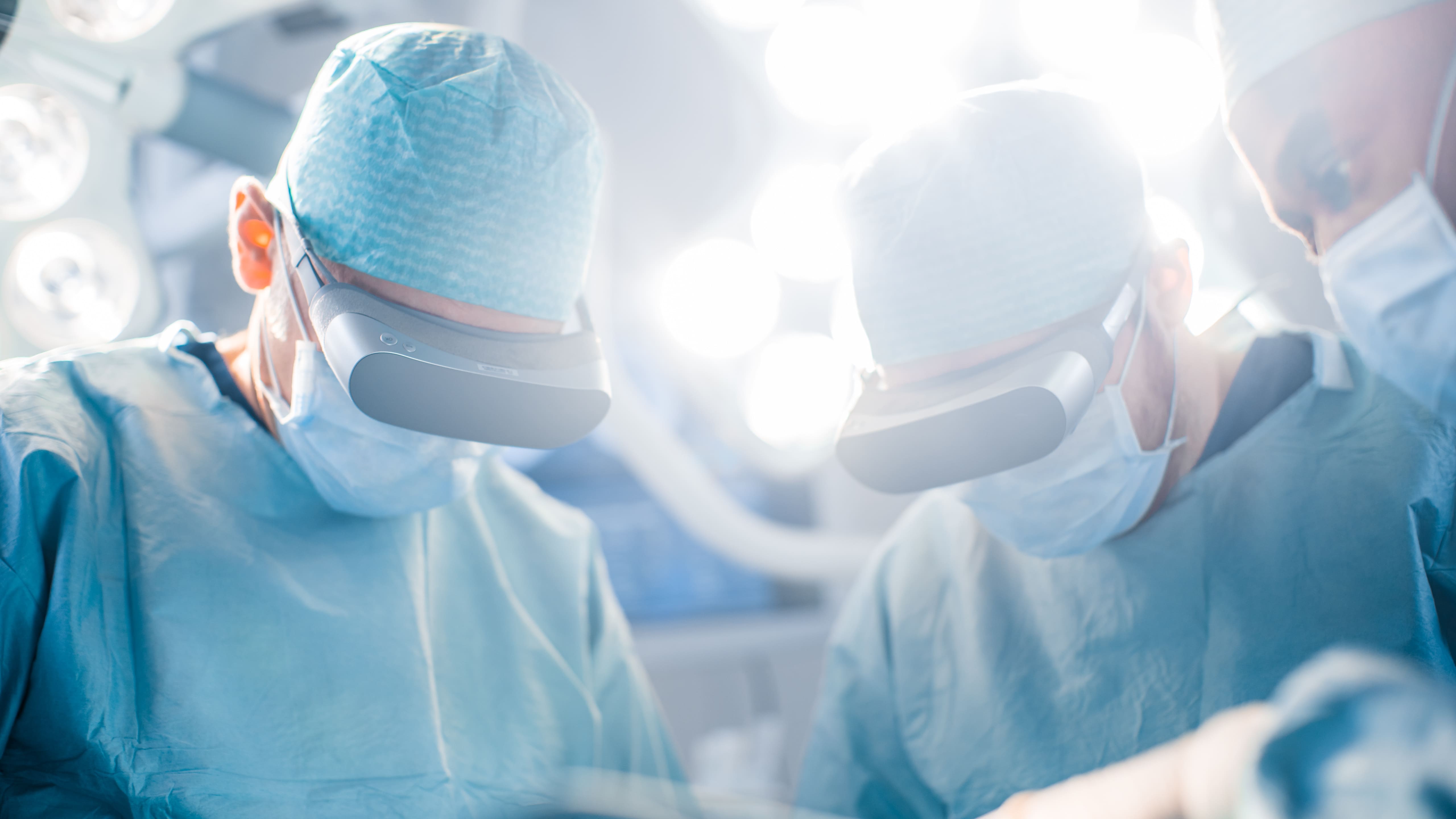 trois médecins dans un bloc opératoire avec des casques de réalité virtuelle